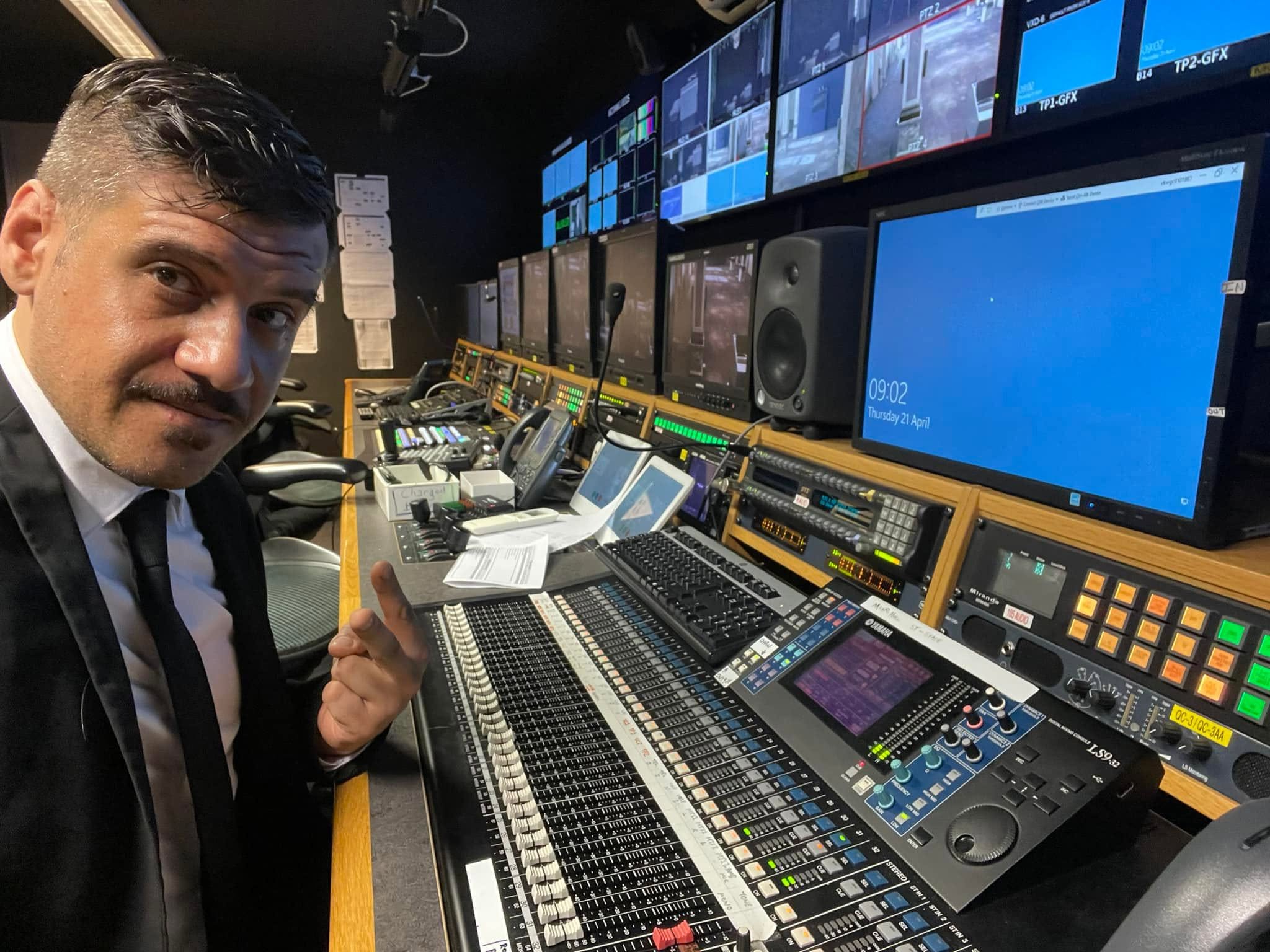 Luigi in an AV control room with video monitors and a Yamaha console