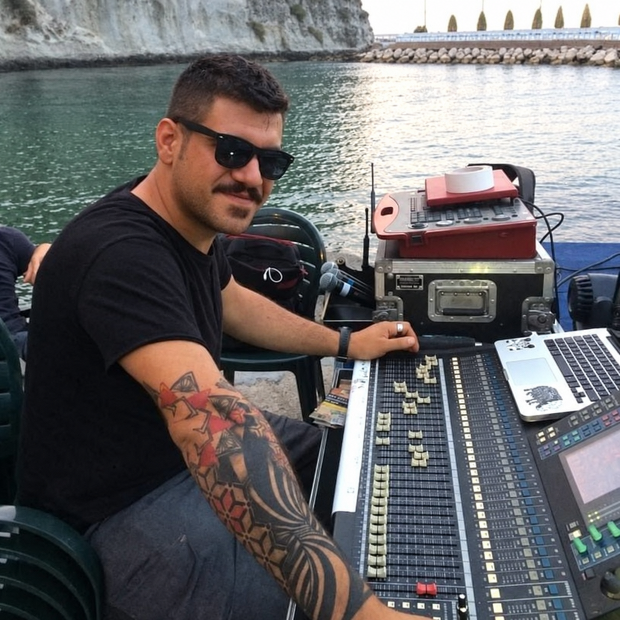 Luigi working at a live sound mixing console beside the water